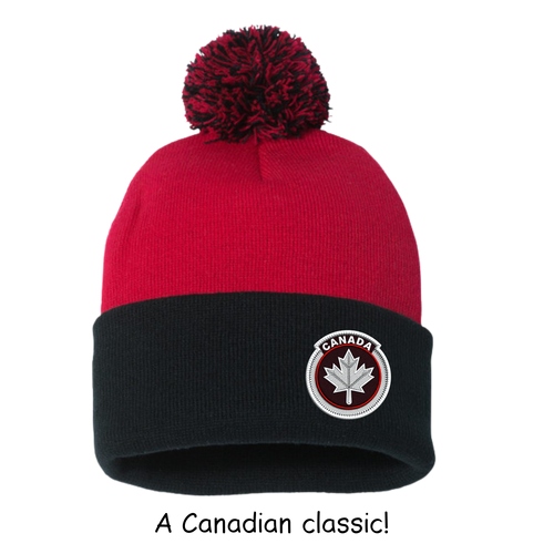 Red and black beanie with a pom-pom and Canada maple leaf logo on a white background.
